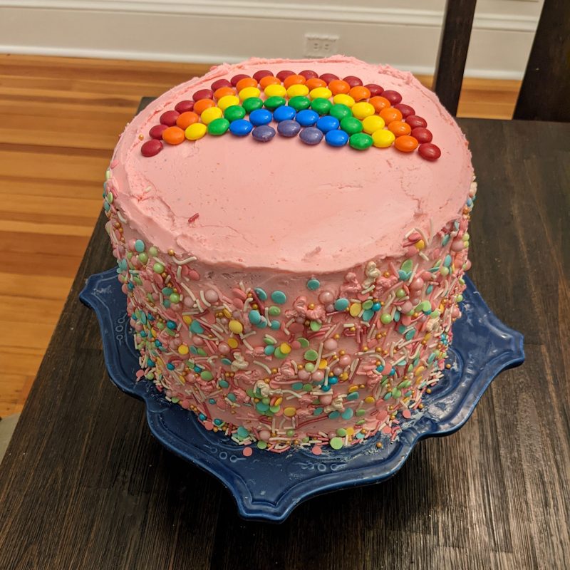 Pink sprinkle cake with a candy rainbow on top