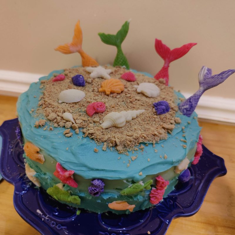 Under-the-sea cake with sand and mermaid tails